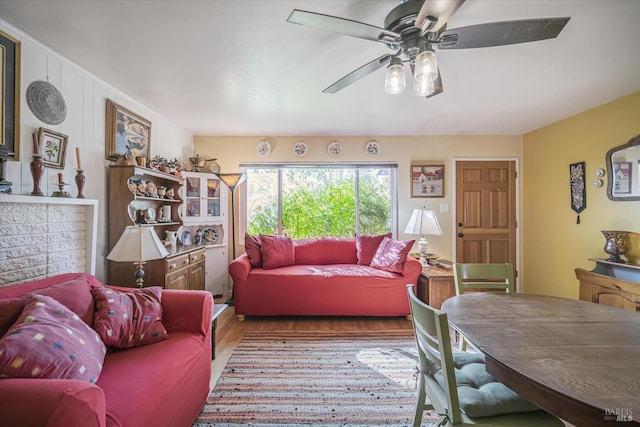 living room with light hardwood / wood-style flooring and ceiling fan