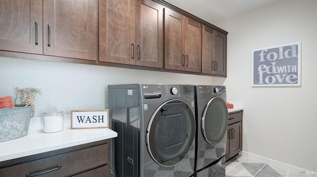 laundry area featuring washer and dryer and cabinets