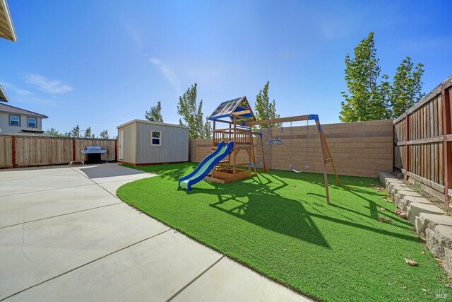 view of play area featuring a patio, a yard, and a shed