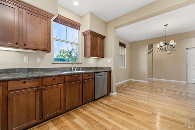 kitchen featuring dark countertops, a sink, a chandelier, baseboards, and stainless steel dishwasher
