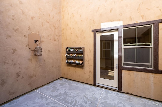 interior space with concrete flooring and wallpapered walls