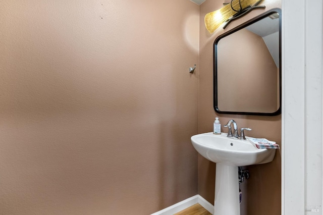 bathroom featuring baseboards and a sink