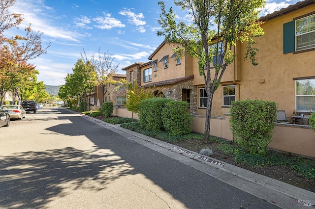 view of road featuring a residential view and curbs
