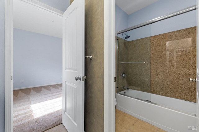 bathroom featuring tile patterned flooring, toilet, and shower / bath combination with glass door