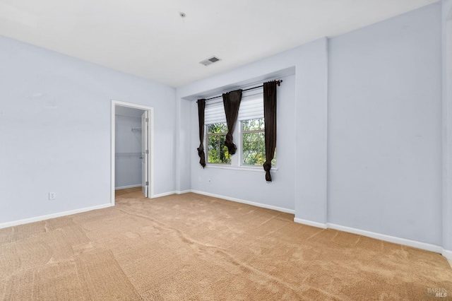 carpeted spare room with baseboards and visible vents