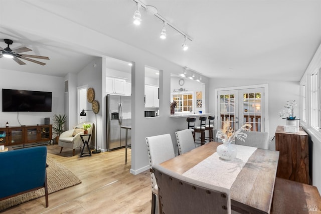 dining room with lofted ceiling, french doors, light wood-style flooring, and baseboards