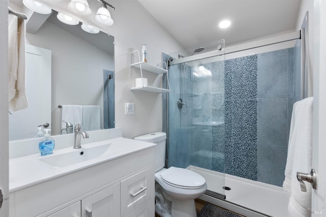 bathroom with a shower stall, toilet, and vanity