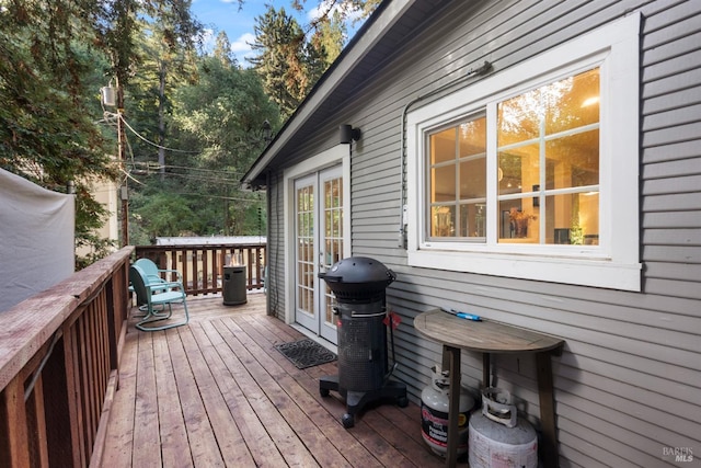 wooden terrace featuring french doors and a grill