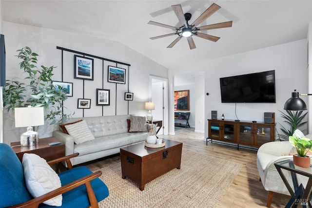 living room featuring lofted ceiling, baseboards, a ceiling fan, and wood finished floors