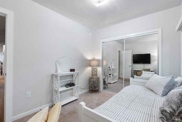 carpeted bedroom with baseboards and a closet