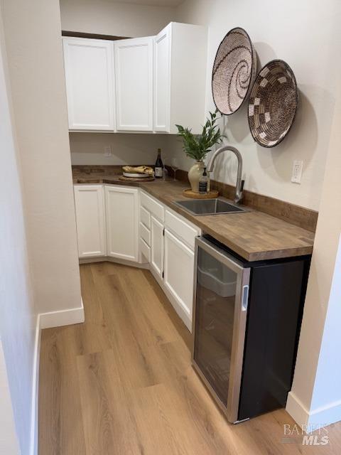 corridor with light hardwood / wood-style floors and sink