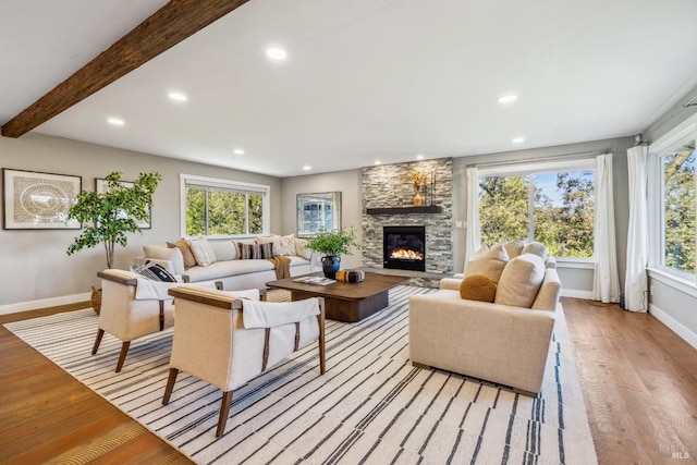 living room featuring plenty of natural light, light wood-type flooring, and a fireplace