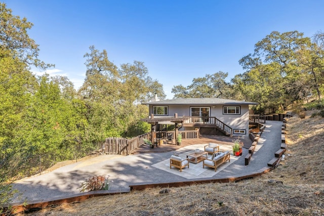 rear view of property featuring an outdoor living space and a deck