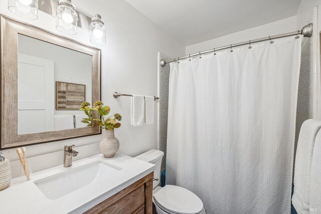 bathroom with vanity, curtained shower, and toilet