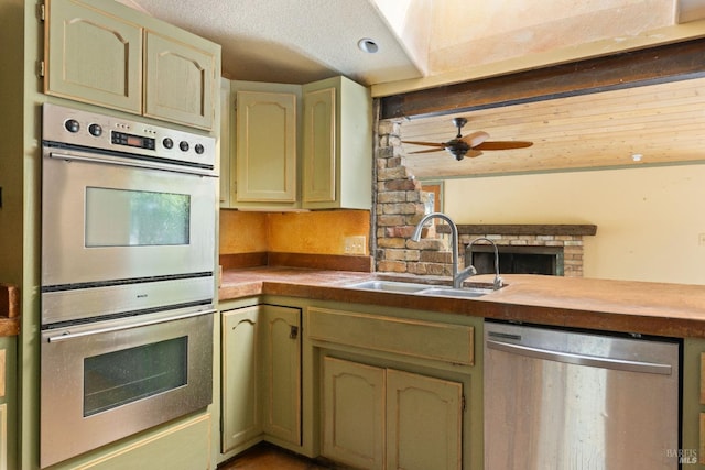 kitchen featuring ceiling fan, a textured ceiling, appliances with stainless steel finishes, and sink