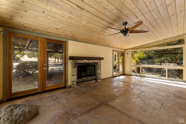 interior space featuring a stone fireplace, concrete flooring, ceiling fan, wooden ceiling, and vaulted ceiling