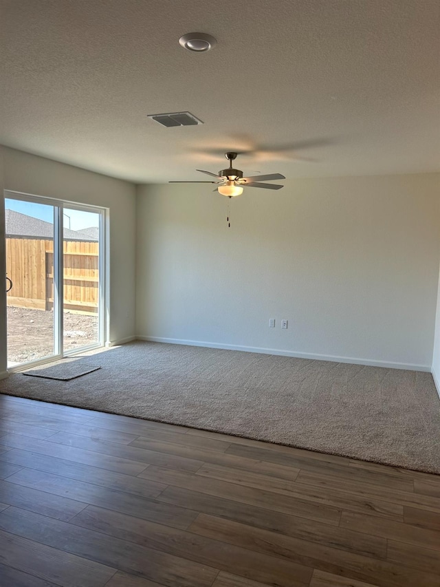 spare room with dark hardwood / wood-style flooring, a textured ceiling, and ceiling fan