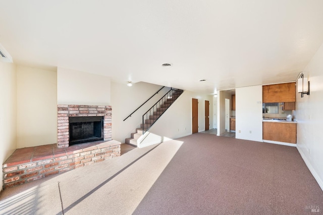 unfurnished living room with carpet floors and a fireplace