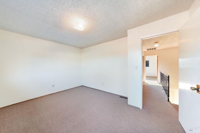 empty room featuring carpet flooring and a textured ceiling