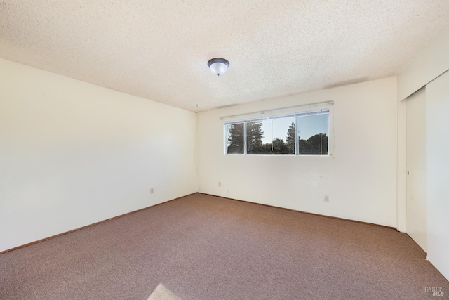 empty room featuring a textured ceiling and carpet floors