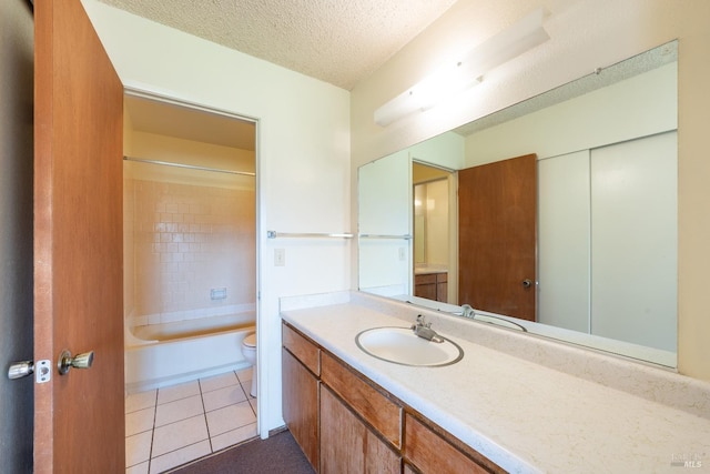 full bathroom with vanity, a textured ceiling, tiled shower / bath combo, tile patterned flooring, and toilet