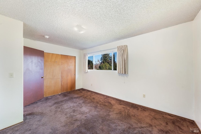 unfurnished bedroom featuring a textured ceiling, carpet floors, and a closet