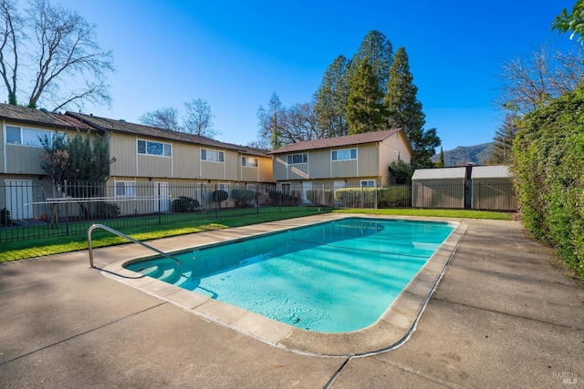 view of pool with a patio area and a yard