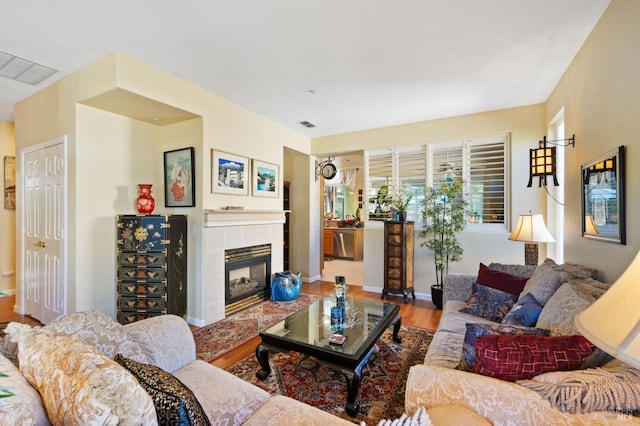 living room featuring hardwood / wood-style flooring and a tiled fireplace