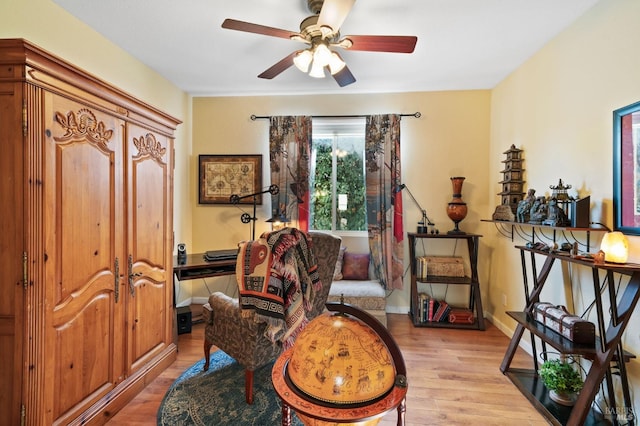 living area featuring light hardwood / wood-style flooring and ceiling fan