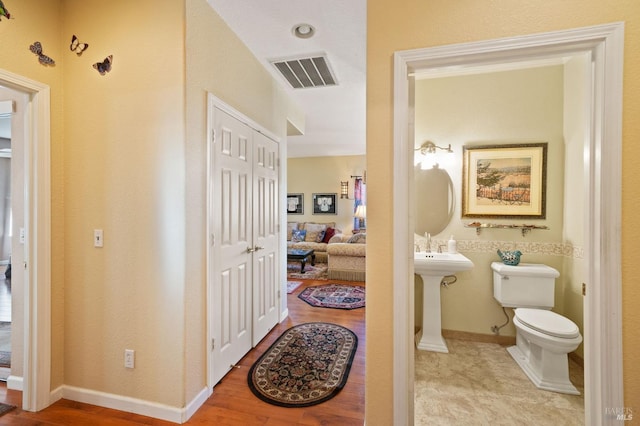 bathroom with wood-type flooring and toilet