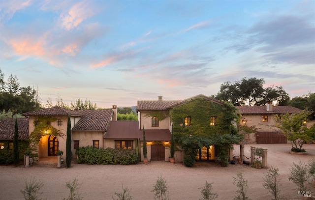 mediterranean / spanish house with driveway, a tile roof, and stucco siding