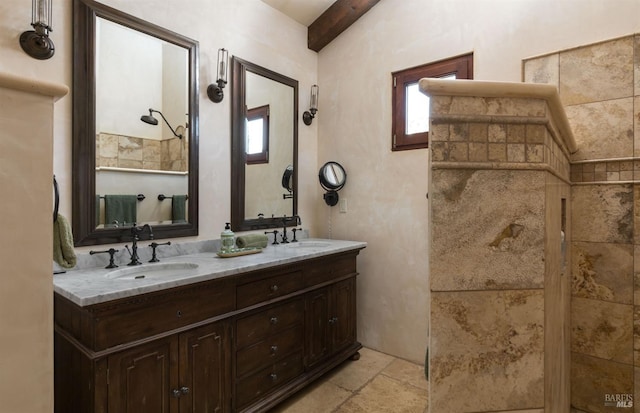 bathroom with double vanity, a sink, and stone tile flooring