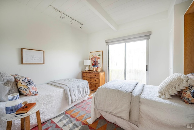 bedroom with beamed ceiling, rail lighting, and access to outside