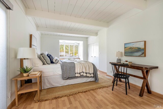 bedroom with beam ceiling, wood ceiling, and wood-type flooring