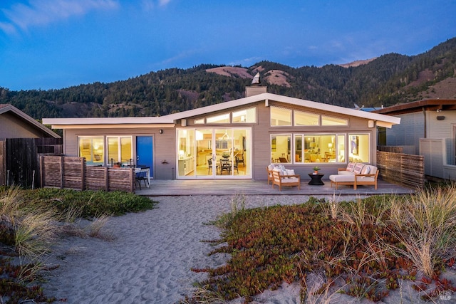 back house at dusk featuring an outdoor living space and a mountain view