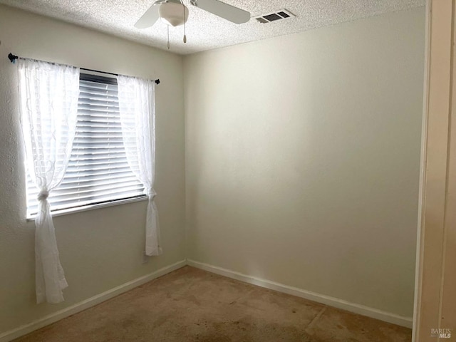 unfurnished room featuring a textured ceiling, ceiling fan, and carpet