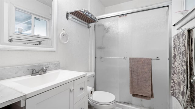 bathroom featuring toilet, an enclosed shower, and vanity