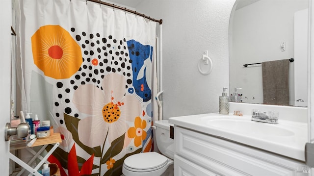 bathroom with toilet, vanity, and curtained shower