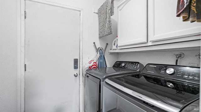 laundry area with separate washer and dryer and cabinets