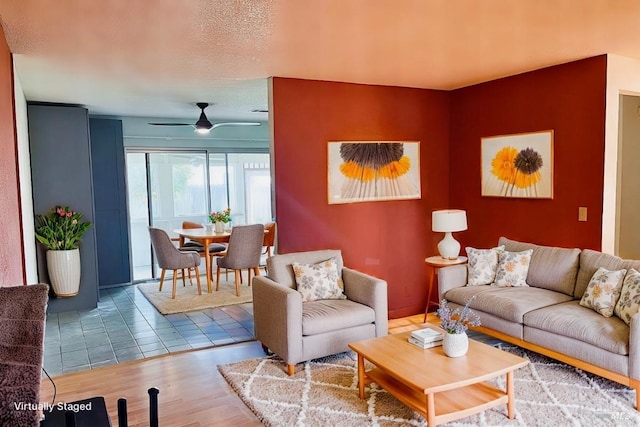 living room featuring a textured ceiling, ceiling fan, and wood-type flooring