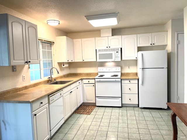 kitchen featuring white appliances, light tile patterned floors, a textured ceiling, white cabinetry, and sink