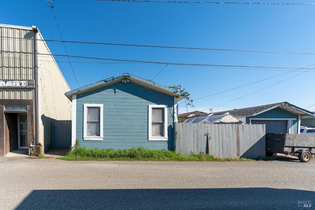 view of home's exterior featuring fence and a detached garage