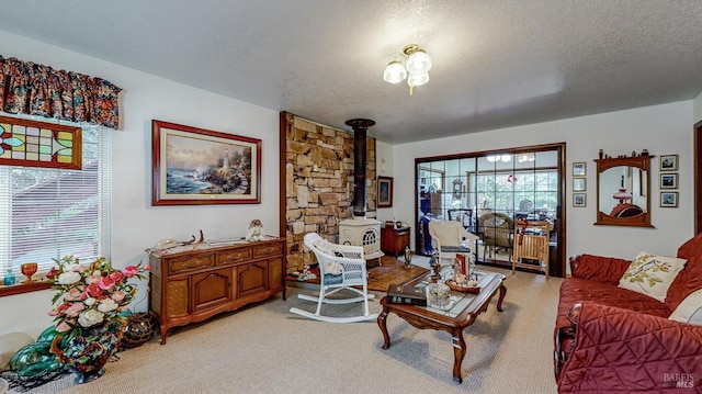 living room with a wood stove, a textured ceiling, and light colored carpet