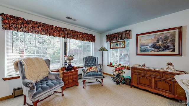 sitting room featuring baseboard heating and light colored carpet