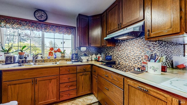 kitchen with light tile patterned flooring, decorative backsplash, and sink