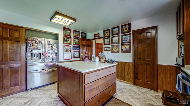 kitchen featuring appliances with stainless steel finishes, wooden walls, and a kitchen island