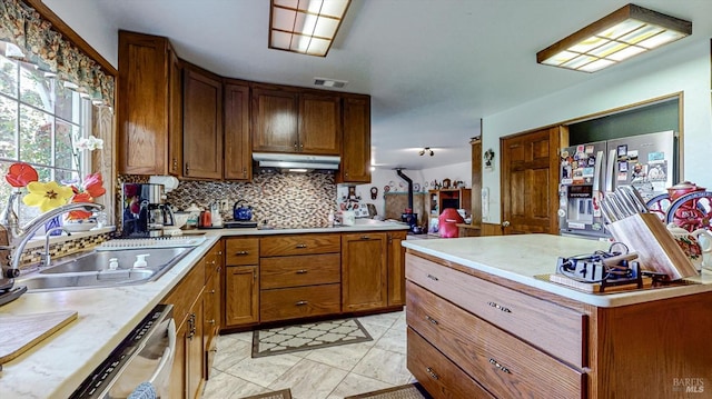 kitchen with stainless steel appliances, decorative backsplash, sink, and light tile patterned flooring