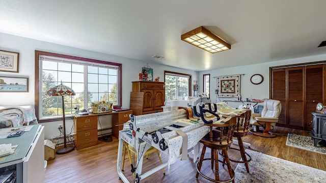 dining area featuring light hardwood / wood-style flooring and a wood stove