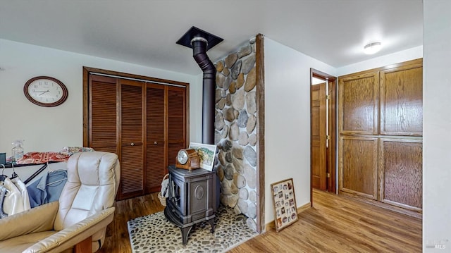 interior space with light hardwood / wood-style floors and a wood stove