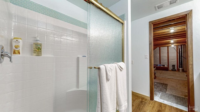 bathroom with a shower with door, wood ceiling, and wood-type flooring